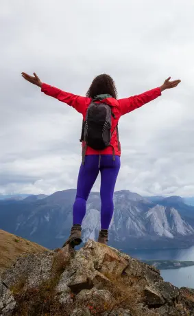 a woman standing on the top of a hill