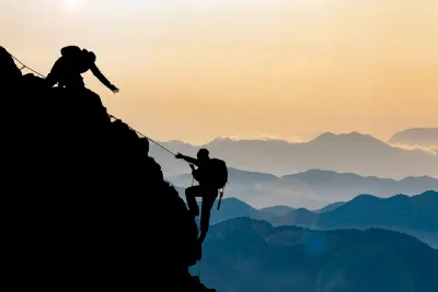 two people climbing on a mountain